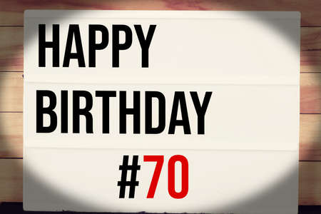 Happy Birthday 70 text on vintage lightbox on wooden background, celebration conceptの写真素材