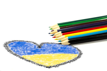 Colored pencils and heart with flag of Ukraine on white backgroundの写真素材