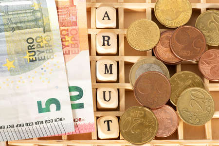 Euro banknotes and coins in a wooden box with the word August