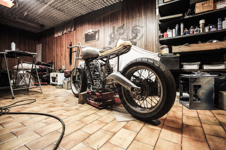 Old vintage motorcycle in garage. Retro style toned picture with shallow depth of field.の写真素材