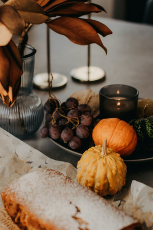 Autumn still life with pumpkins, grapes, candlestick and candles on tableの写真素材