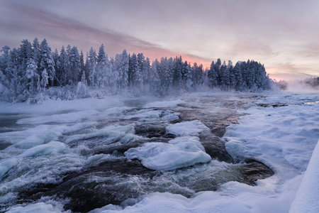 Beautiful winter landscape with frozen river and forest at sunset. Finlandの写真素材