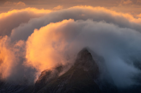 Mountain landscape with clouds and fog at sunset, Alps, Switzerlandの写真素材