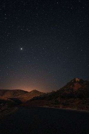Night landscape with starry sky and a road through the desert.