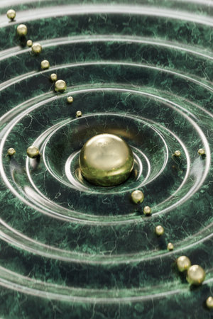 Water drop in green color with pearls on it. Abstract background.