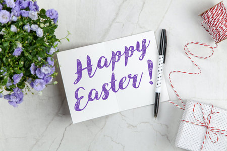 Greeting card with Happy Easter lettering and flowersle backgroundの写真素材