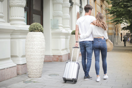 Young couple with luggage on city street. Travel and vacation concept.の写真素材