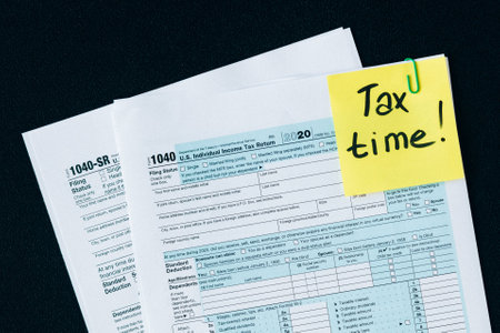 Tax form 1040 with yellow sticky note on a black background.の写真素材