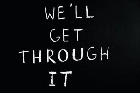 We all get this together handwritten with white chalk on a blackboardの写真素材