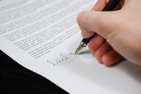 Close-up of a hand signing a contract with a fountain penの写真素材