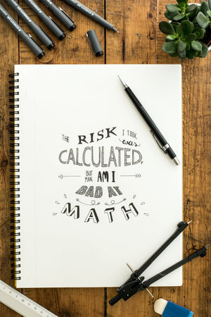top view of notebook with calligraphy and drawing tools on wooden table
