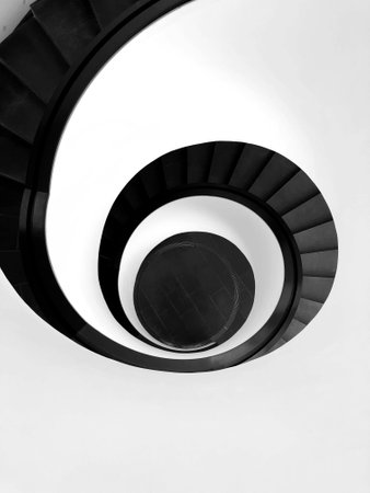 Spiral staircase on white wall. Black and white photo.の写真素材