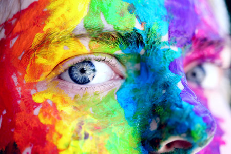 Close-up of the face of a girl painted with bright colors