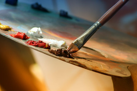 Paint brushes and palette of colors on the table in a studioの写真素材