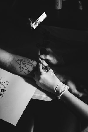 Tattoo artist draws a sketch on the skin of a young girlの写真素材