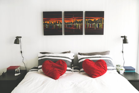 Bedroom interior with two red pillows on bedside table, stock photo