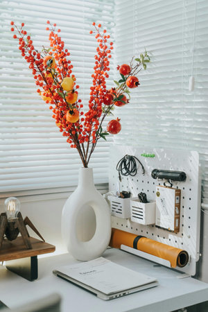 Interior of modern home office with a vase of orange berries
