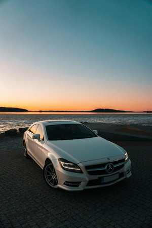 White sport car on the beach at sunset. Car in the evening.
