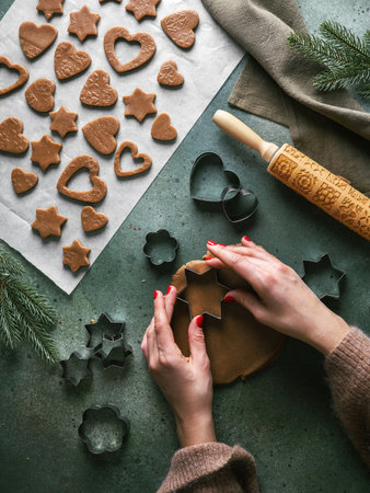 Woman making christmas gingerbread cookies. Flat lay, top view