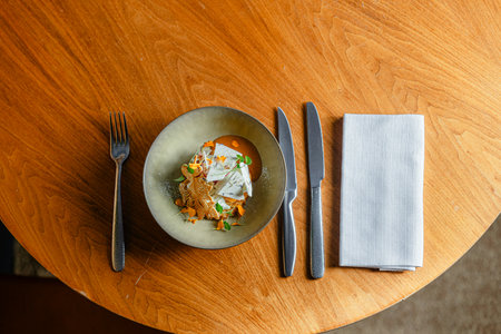 Top view of plate and cutlery on the wooden table.