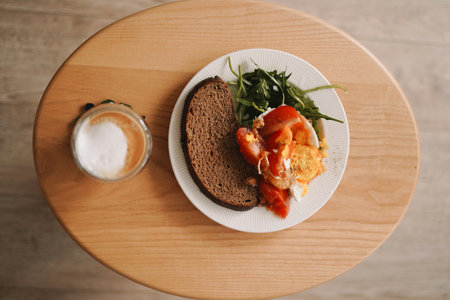 Breakfast with bread and scrambled eggs on wooden table, top viewの写真素材