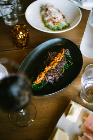 beef steak on a black plate on a wooden table in a restaurantの写真素材