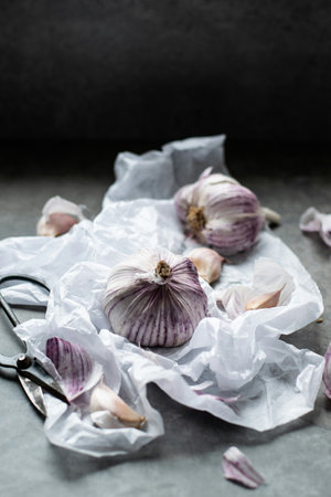 Garlic bulbs and cloves on crumpled paper, selective focus