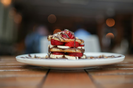 Delicious waffles with strawberries and chocolate on a wooden table.の写真素材