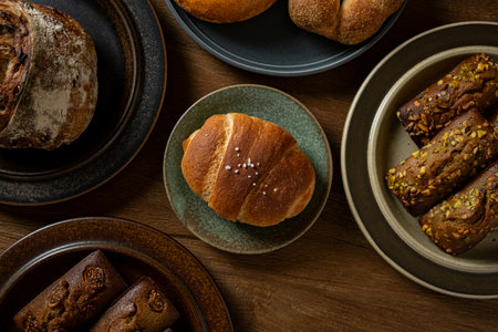 Top view of croissants and buns in bowls on wooden table