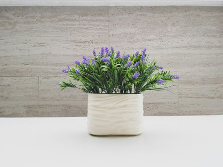 Vase with purple flowers on the table.