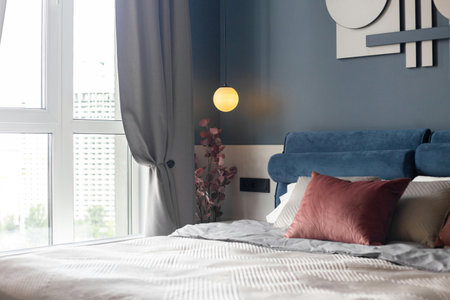 modern bedroom interior design with blue and pink pillows on the bedの写真素材