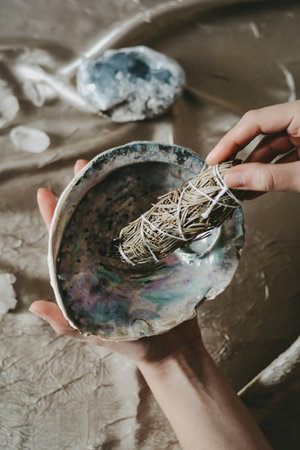Close-up of a child's hands holding a clay bowl with painted Easter eggs