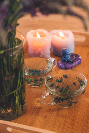 Cup of tea with lavender and candle on wooden table.の写真素材