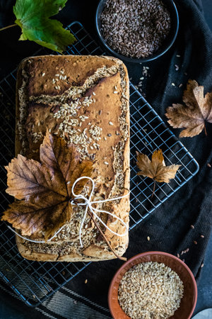 Whole grain bread with flax seeds and raisins on a black background