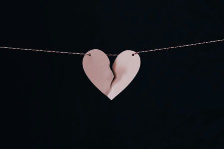 Two paper hearts on a rope on a black background. Valentine's Dayの写真素材