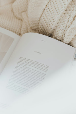 White knitted sweaters and a book on a white background.の写真素材