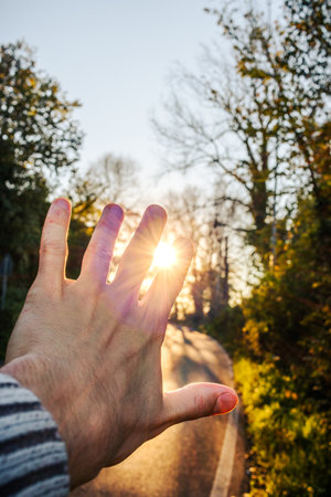 hand reaching towards the sun. Sunset in nature near Rome Italy. Lanuvioの写真素材