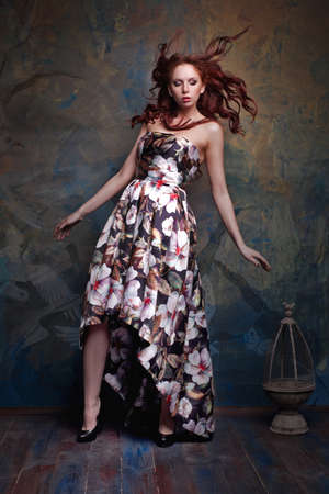 curly woman in a colorful dress posingの写真素材