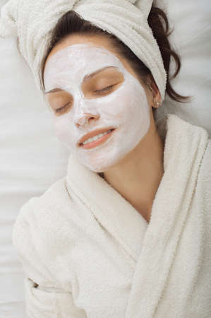 Close-up portrait of beautiful girl with a towel on her head  facial mask