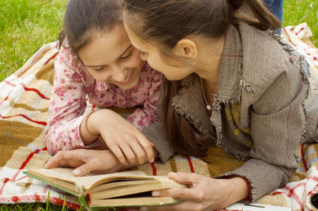mother and daughter reading book and smiling