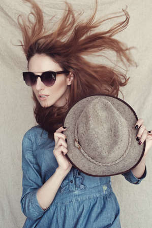 young girl with glasses holding a hatの写真素材