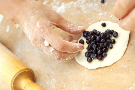 pastry chef wraps in dough bilberry on a wooden boardの写真素材