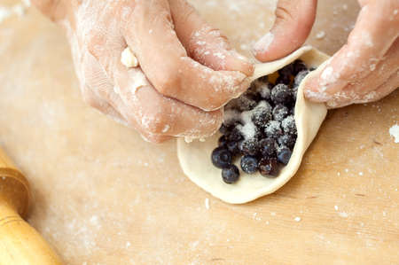 pastry chef wraps in dough bilberry on a wooden boardの写真素材