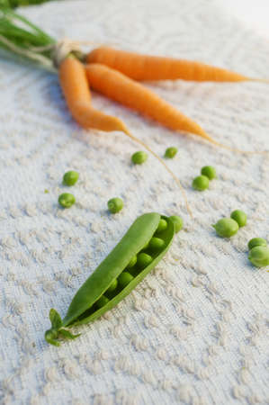 open pod of peas on a napkin with an ornamentの写真素材