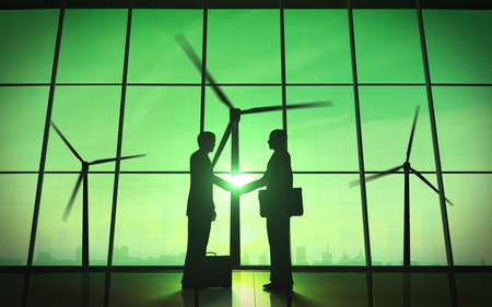 Green business shake hand silhouette with windmill 