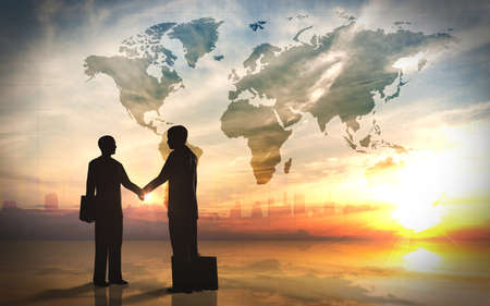 Two business man shake hand silhouettes city with world maps の写真素材