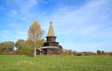 wooden chapel on green fieldの写真素材