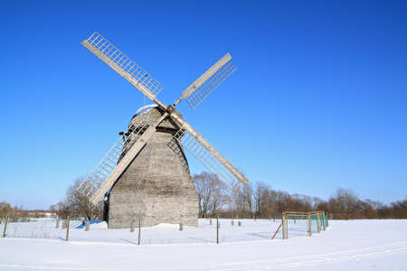 aging wind mill on winter fieldの写真素材