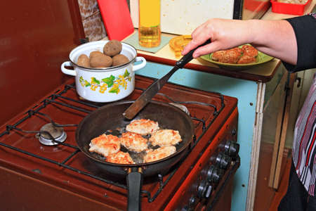 woman fries chops on black griddleの写真素材
