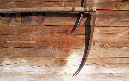 agricultural grunge background, scythe on wooden wallの写真素材